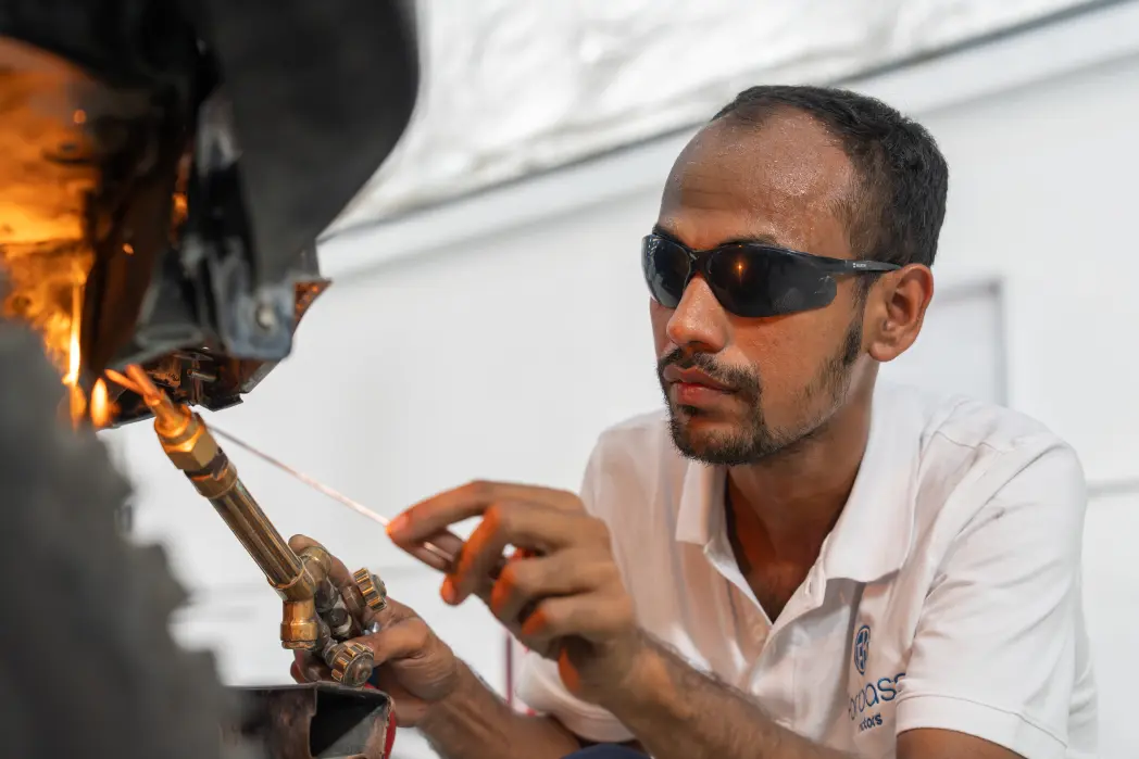 Technician servicing a car with open hood at Forbass Motors